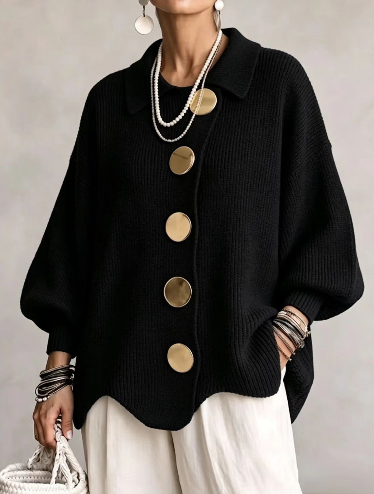 Loose-fitting solid color collared knit sweater with metal buttons and an irregular hem