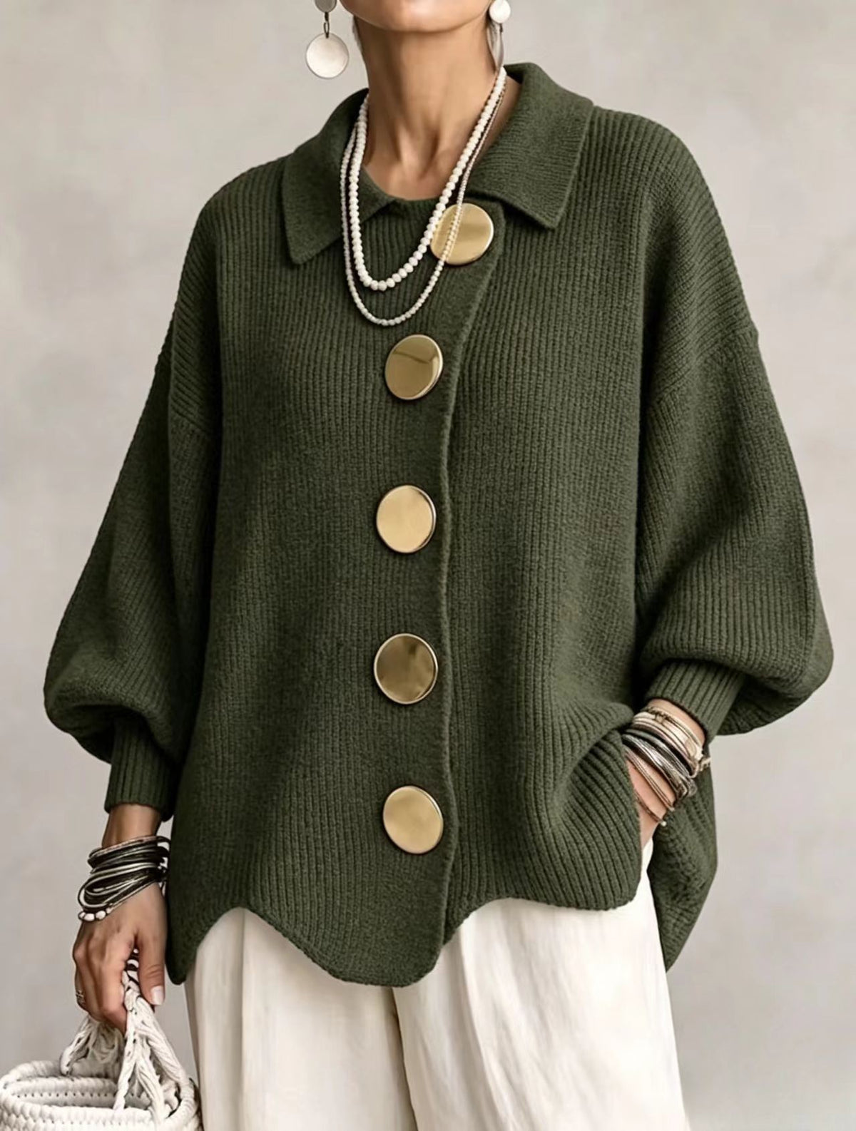 Loose-fitting solid color collared knit sweater with metal buttons and an irregular hem